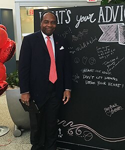 Photo of Dr. Griffen P. Rodgers standing next to chalk board where he composed the message 'Heart-felt advice - don't let diabetes break your heart!'