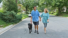 Photo of man and woman walking with dog