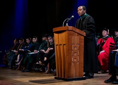Photo of Dr. Griffin P. Rodgers delivering the keynote address at George Washington University’s 2018 M.D. Diploma Ceremony.