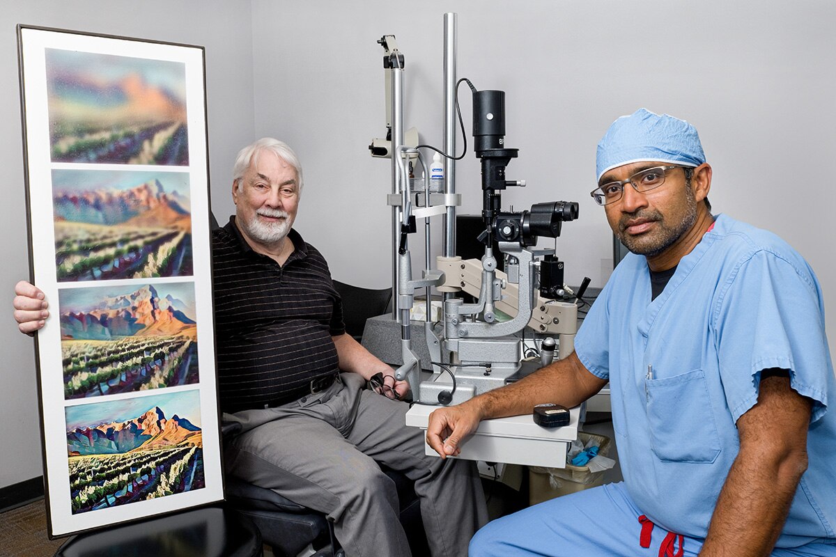 An eye doctor sitting with a patient holding a series of increasingly blurry images