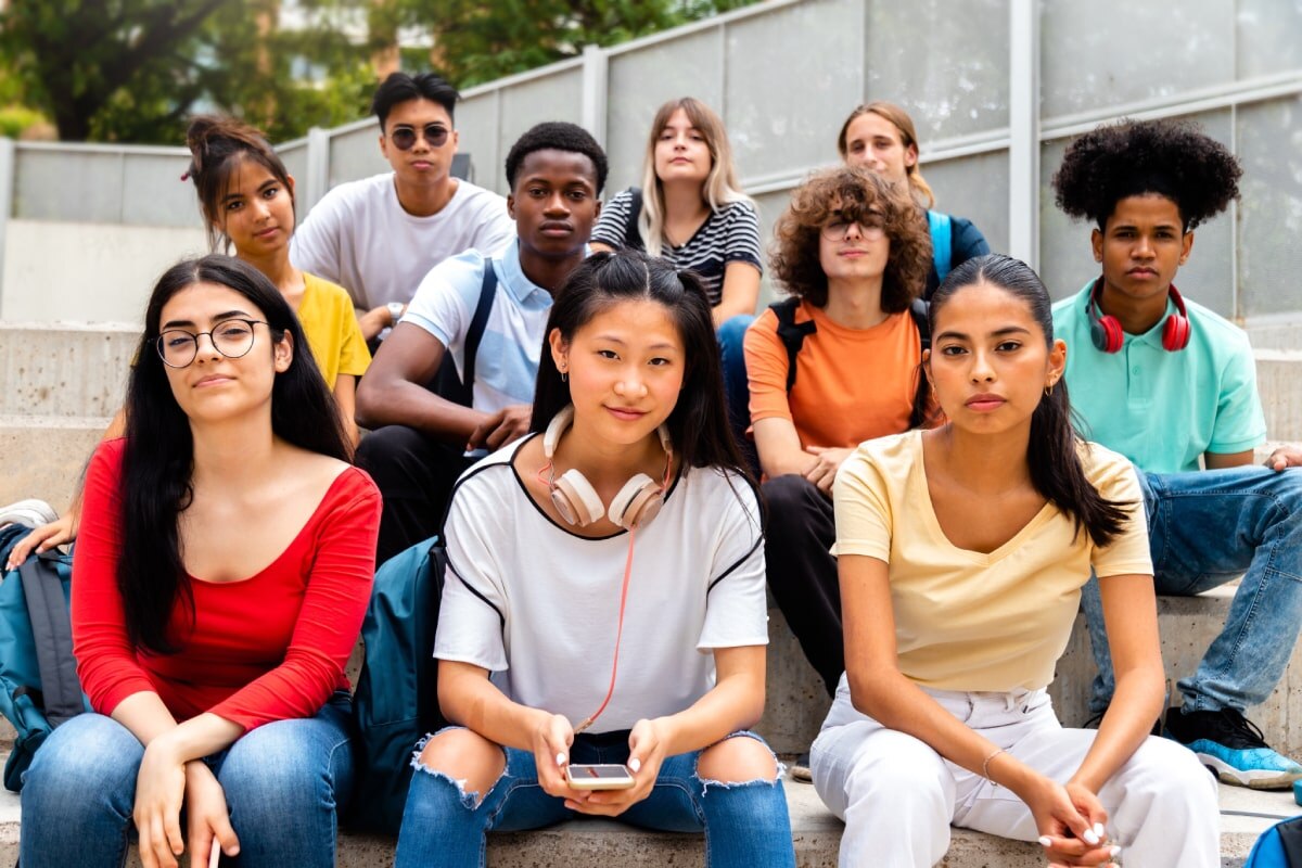 Diverse group of students sitting on the stairs outdoors.