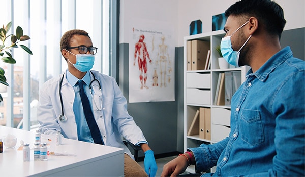 Health care professional with patient wearing masks