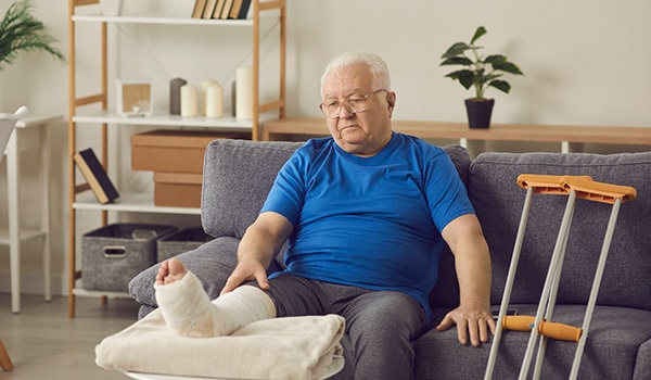 Man sitting on couch with elevated broken leg