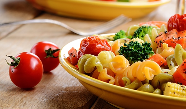 A bowl of pasta with vegetables.
