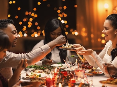 A man putting food on a woman's plate at a holiday dinner.