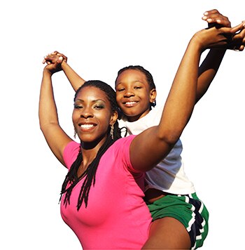 Madre afroamericana con una camiseta rosada que tiene a su hijo trepado en su espalda.