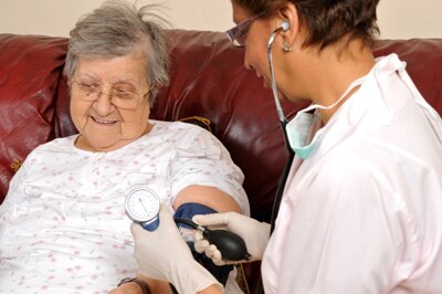A woman having her blood pressure checked by a health care professional.