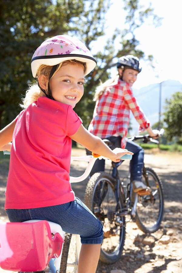Photo of mother and young daughter riding bikes