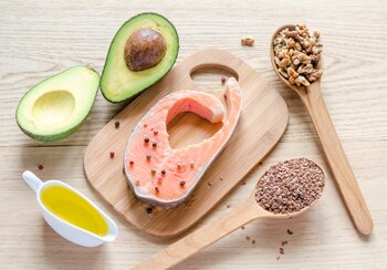 Photo of avocado, salmon, nuts, seeds, and olive oil.