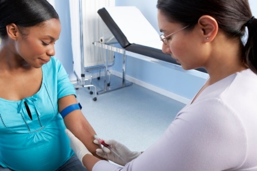 Una mujer embarazada a quien le están tomando una muestra de sangre.