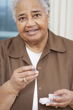 An older woman taking her medicine.