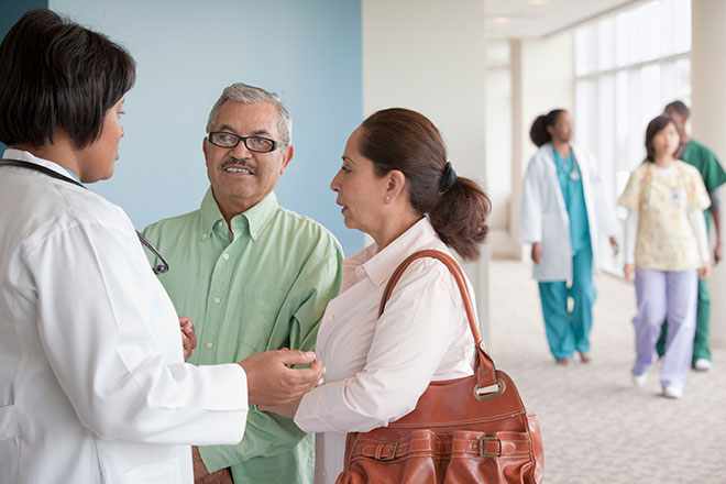 Health care professional talking with a patient and the patient’s family member.