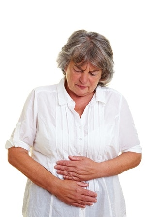 Woman clutching her stomach which is in pain.