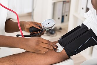 A doctor checking a patient’s blood pressure.