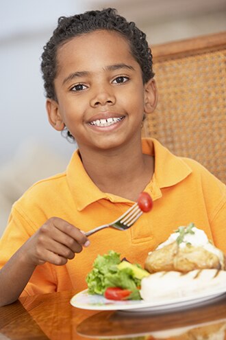 Foto de un niño comiendo una cena saludable.