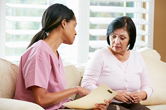 A health care professional speaks to a woman in a professional setting.
