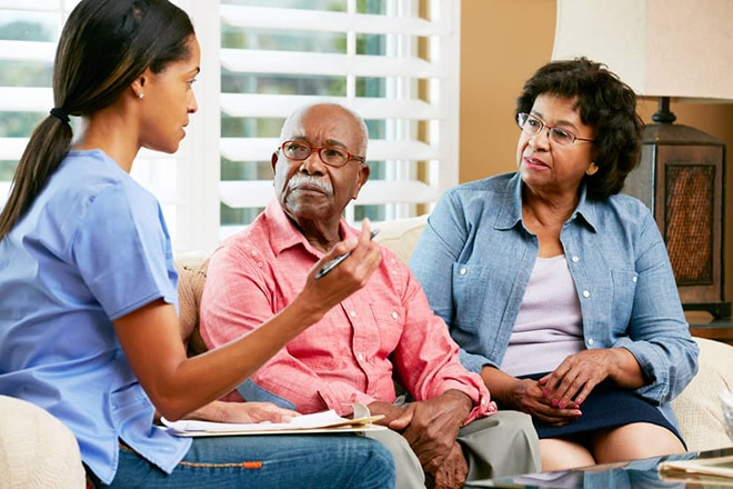 Health care professional talking with a patient and a member of the patient’s family.