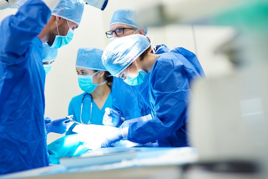 Grupo de cirujanos haciendo una cirugía en una sala de operaciones.