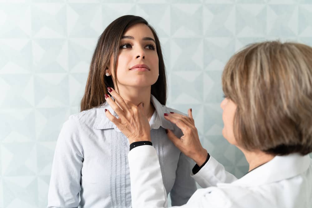 Doctora examinando el cuello de una mujer joven