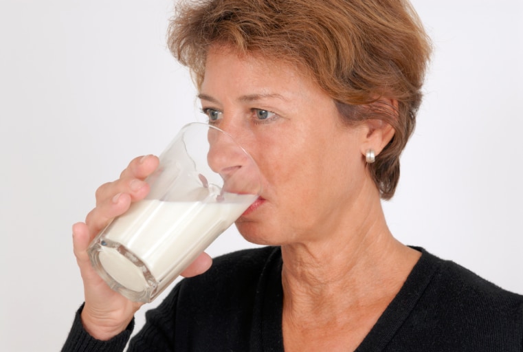 Mujer tomando un vaso de leche.