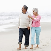a senior couple walking on the beach