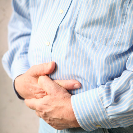 a man holds both hands to his stomach