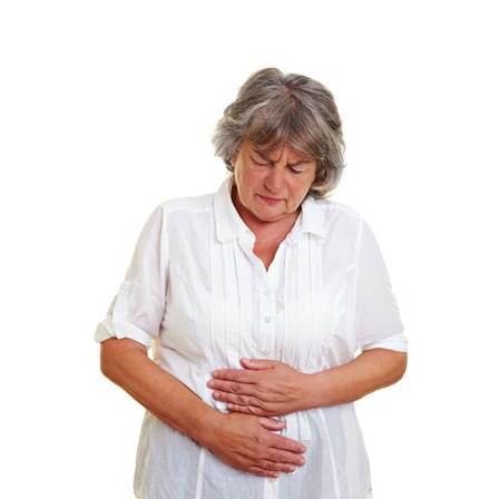 Elderly woman with gray hair holding her aching stomach
