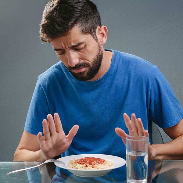 man with no appetite in front of a meal