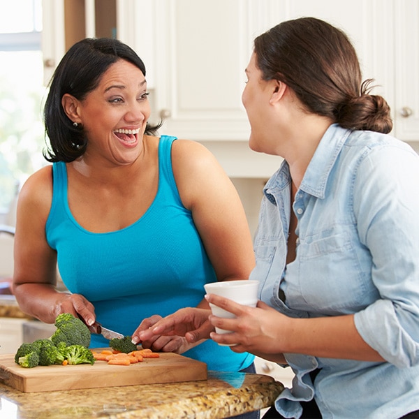 Dos mujeres en una cocina preparando comida juntas. 