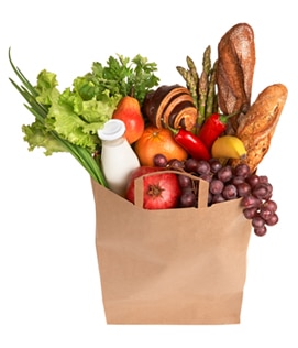 Una bolsa de comestibles que contiene frutas, verduras, leche y pan.