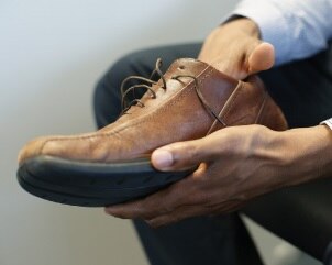 Un hombre toca el interior del zapato.
