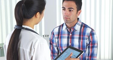Un profesional de la salud que habla con un paciente en su oficina