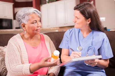 Foto de un médico hablando de medicinas con un paciente anciano.