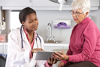 Photo of doctor talking with elderly woman about a diagnosis