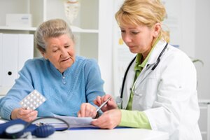 A photo of a health care provider talking about medicine to an older patient.