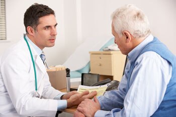 Male doctor talking with an older male patient.