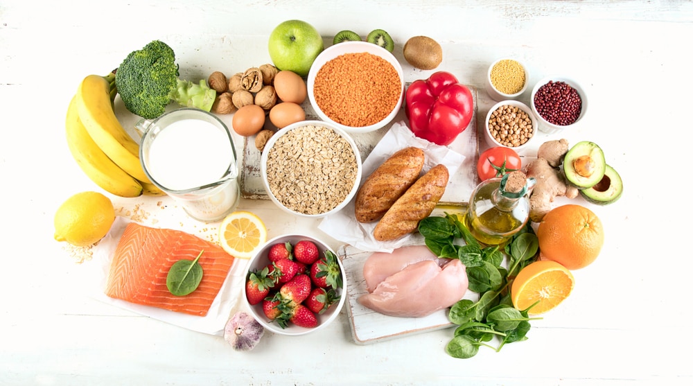 A display of fresh vegetables, beans, fruit, fish, lean proteins, healthy fats, whole grains, and milk.