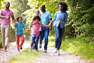 Four adults and two children strolling along a wooded trail