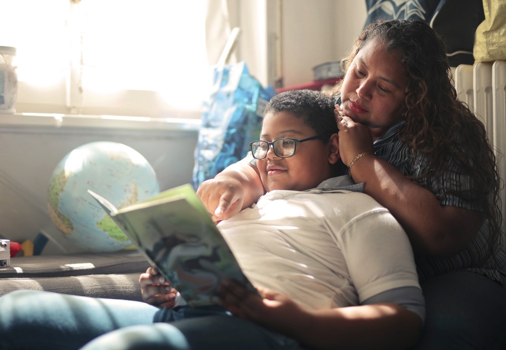 Mother and son reading a book together at home.