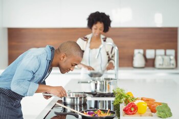 A couple cooking vegetables