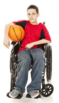 Photo of  boy sitting in wheelchair holding basketball