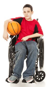 Photo of boy sitting in wheelchair holding basketball