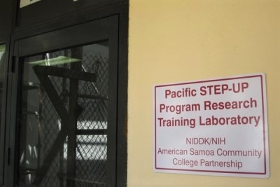 A door next to a sign identifying the NIDDK Pacific STEP-UP Program training laboratory in American Samoa.