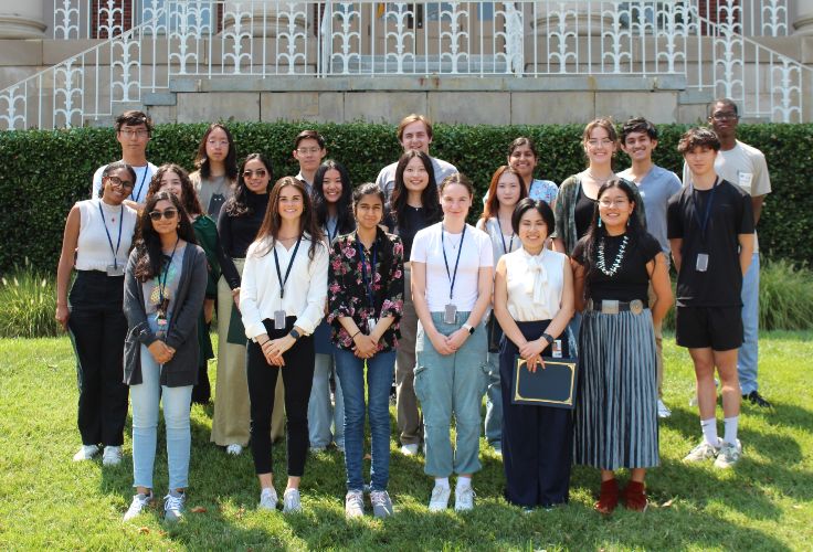 A group of the 2024 summer interns smiling and standing outside.