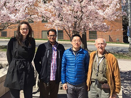 NIDDK Carbohydrates Section staff standing in front of a cherry blossom tree.