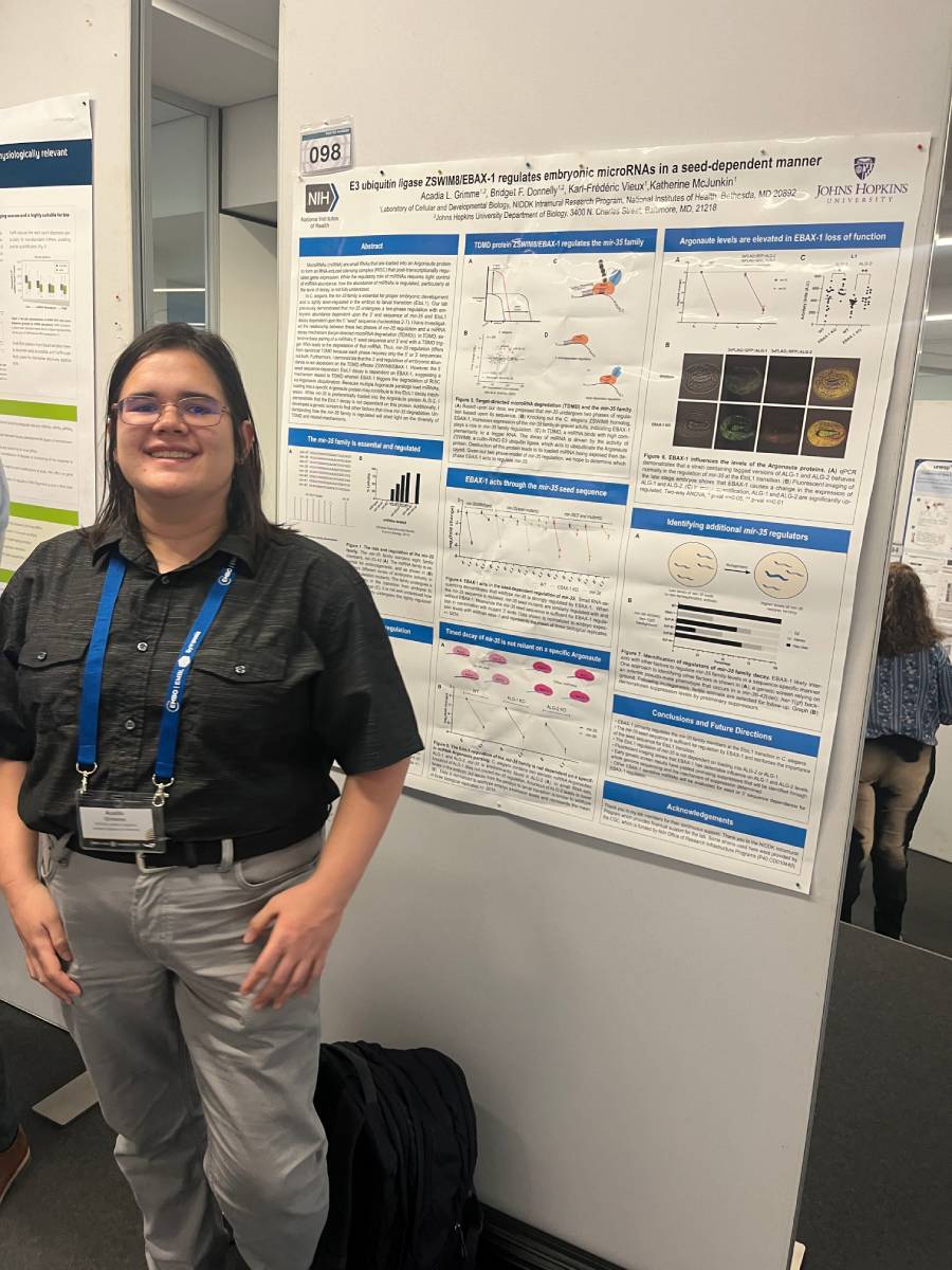 NIDDK Section on Regulatory RNAs lab member posing in front of poster at the EMBO EMBL Noncoding Genome Symposium.