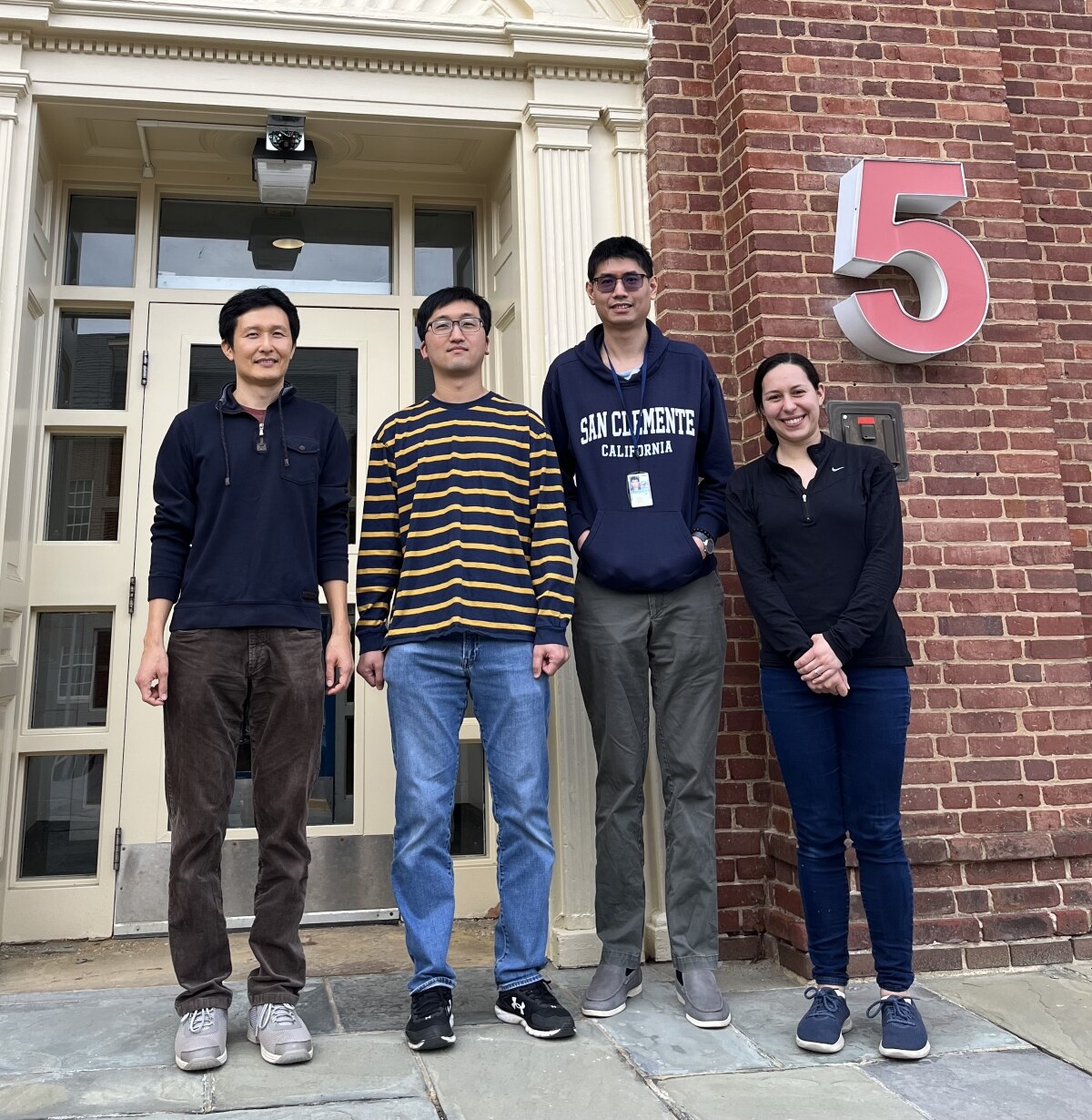 Lab members standing outside and smiling.